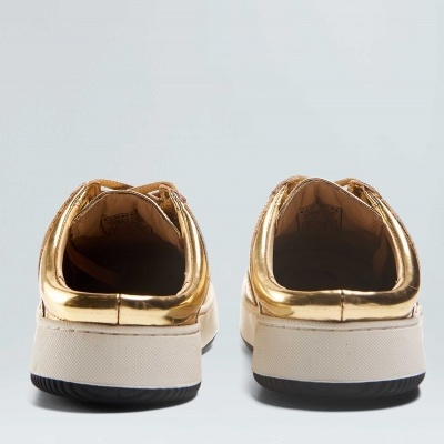 Ténis dourados vistos de trás com sola branca