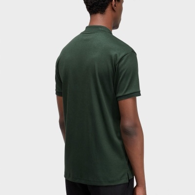 Homem de costas com camisa polo verde escura e calças pretas