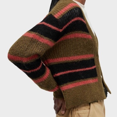 Cardigan de malha castanho com riscas pretas e corais usado com calças beges.