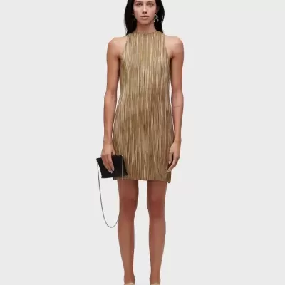 Vestido dourado plissado com mala preta e sapatos bege