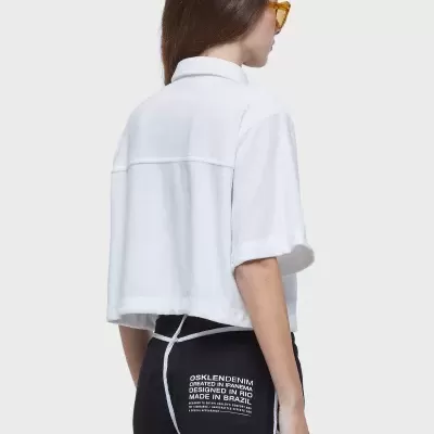 Pessoa de costas com camisa branca e calções pretos com texto branco