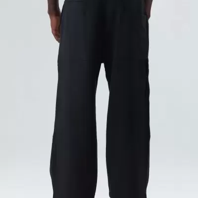 Calças largas pretas com bolsos grandes vistas de trás.