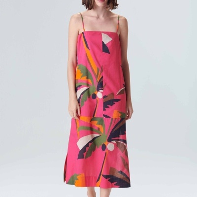 Vestido rosa com padrão de folhas e alças finas, usado com chapéu de ráfia e sandálias