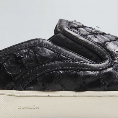 Tênis slip-on preto com textura de pele de réptil e sola branca OSKLEN