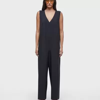 Macacão azul escuro sem mangas com ténis vermelhos e óculos de sol laranja