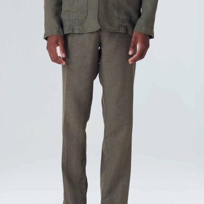 Homem com conjunto verde oliva de calças e casaco com botões e bolsos, calçado preto desportivo