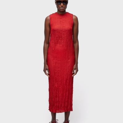 Vestido midi vermelho sem mangas com textura enrugada, pessoa com óculos escuros e sapatilhas bordô