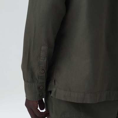 Camisa manga comprida e calça verdes-oliva com botões e costuras visíveis