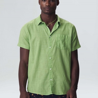 Homem a usar camisa verde clara de manga curta com bolso no peito