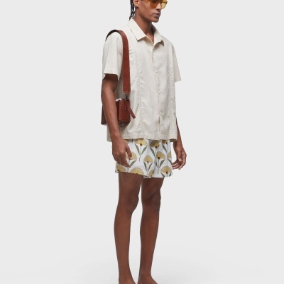 Homem com roupa casual clara e mala castanha em fundo branco