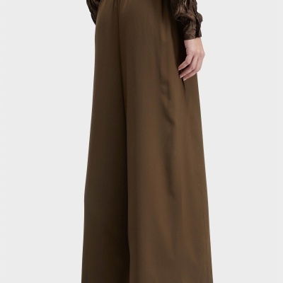 Pantalonas compridas castanhas com cintura alta elástica vistas de trás, combinadas com sandálias castanhas e camisa castanha com textura franzida