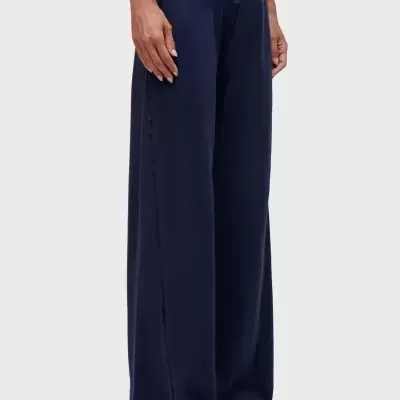 Calças largas azul escuro com cordão na cintura e sapatos brancos abertos