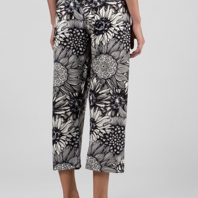 Calças capri florais preto e branco usadas por mulher, vista de costas