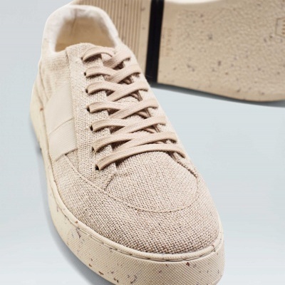 Ténis bege em tecido texturado com atacadores e sola clara com manchas escuras