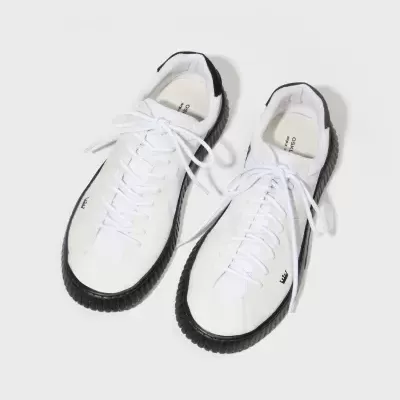 Ténis brancos com sola preta e detalhes pretos