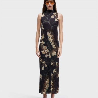 Mulher usando vestido comprido preto com padrão floral e óculos de sol laranja