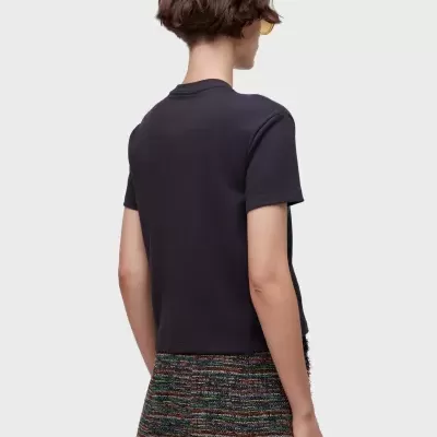 T-shirt preta manga curta com mini saia colorida texturizada vista de costas.