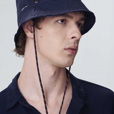 Homem com chapéu bucket azul escuro e camisa azul