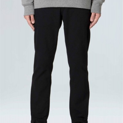 Calças pretas com corte ajustado usadas por pessoa com casaco cinza