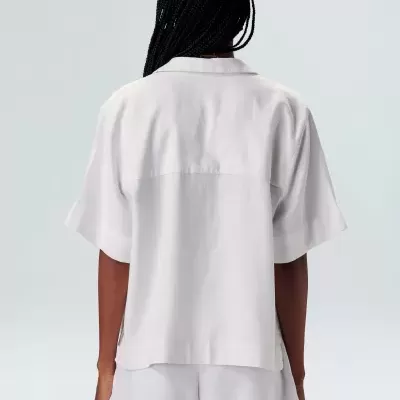 Conjunto branco de camisa e calções visto de costas