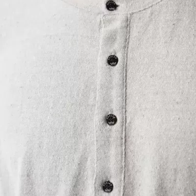 Camisola branca de malha com botões pretos na frente e textura visível