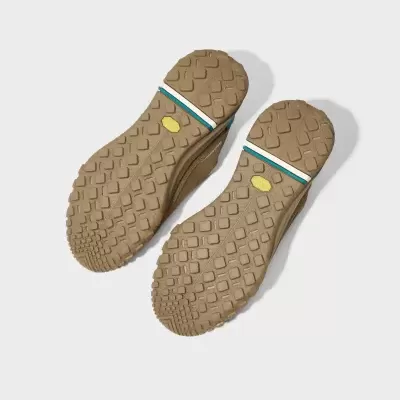 Solas de sapatos de borracha bege com padrão antiderrapante e detalhes coloridos.