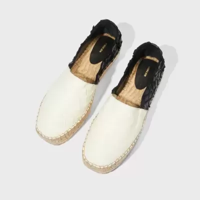 Alpargatas bege claro e preta com sola de cortiça e texto OSKLEN