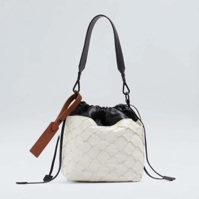 Mala saco branca texturada com alça preta e detalhes castanhos