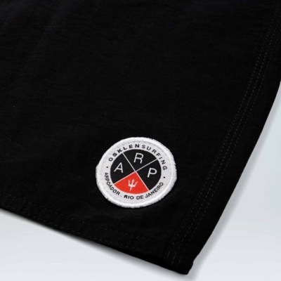 peça de roupa preta com remendo redondo branco e texto OSKLEN SURFING ARPOADOR RIO DE JANEIRO
