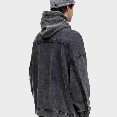Homem visto de costas com gorro cinzento e casaco cinzento com capuz.