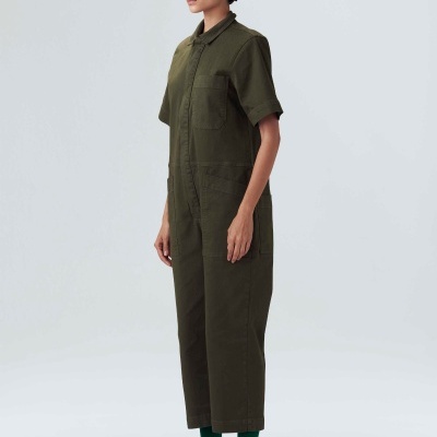 Pessoa a usar macacão verde-oliva de manga curta com bolsos frontais