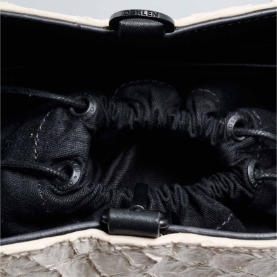 Mala bege com textura de pele e interior preto com cordão e tacha preta