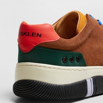 Ténis castanho com detalhes multicolores e sola branca e preta