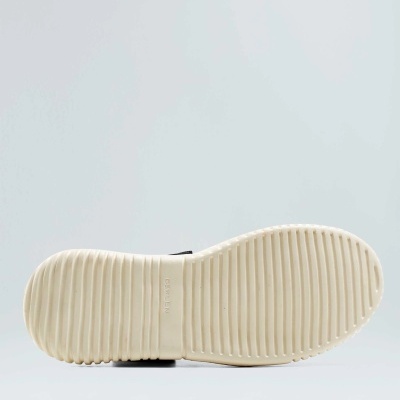 Sola creme de calçado com padrão listrado e texto CHARLES