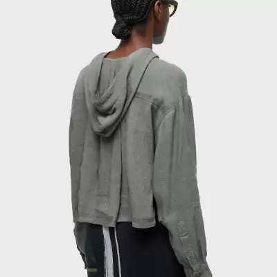 Casaco cinzento claro com capuz e botões no punho visto de costas