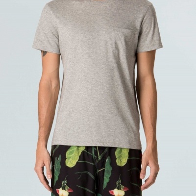 Homem com t-shirt cinzenta e calções pretos com padrão de folhas e flores