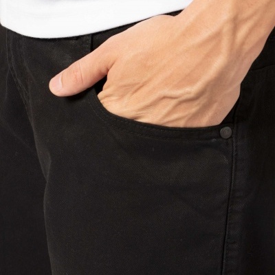 Mão esquerda numa calça preta com botão e t-shirt branca