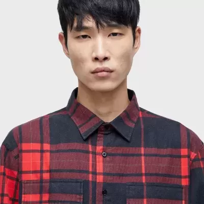 Camisa xadrez vermelha e preta com bolsos no peito, colarinho clássico em modelo masculino