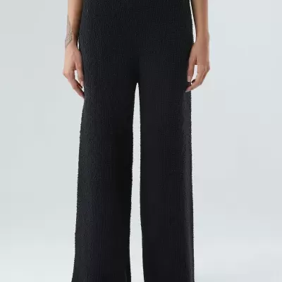 Calças pretas de tecido texturizado com corte largo e cintura alta