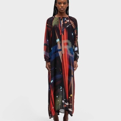 Vestido longo colorido com padrão abstrato usado por mulher com sandálias castanhas