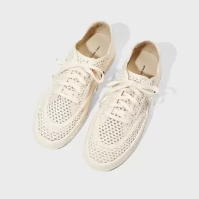Sapatilhas brancas de malha perfurada com atacadores e sola clara