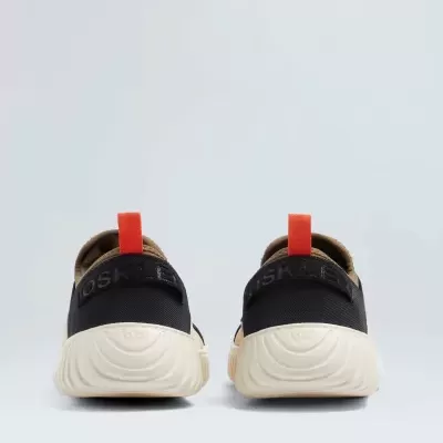 Sapatilhas castanhas e pretas com sola branca vistas de trás