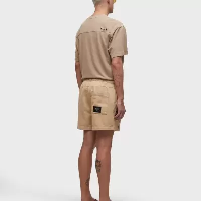 Homem de costas a usar roupa casual bege e sandálias castanhas