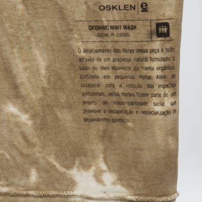 Etiqueta com texto explicativo em peça de roupa bege com padrão tie-dye