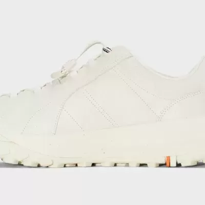 Tênis desportivo branco com sola grossa e atacadores elásticos.