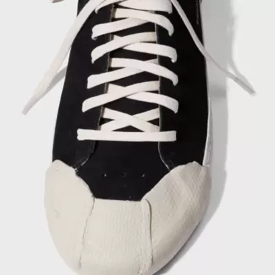 Ténis preto com sola e ponta branca e atacadores brancos