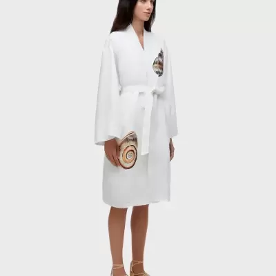 Robe branco com estampas de conchas e cinto branco usado por mulher