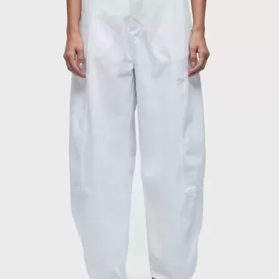 Calças brancas largas com botão preto e sapatos brancos