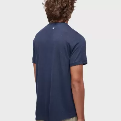 Pessoa de costas com t-shirt azul escura e calções bege