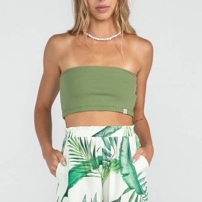 Modelo com top bandeau verde musgo e calções brancos com padrão de folhas verdes